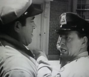 Image of actor John Payne in a film being aggressively detained by an uncredited actor